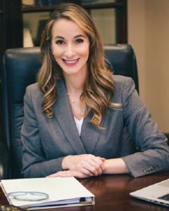 Smiling woman at desk, business attire